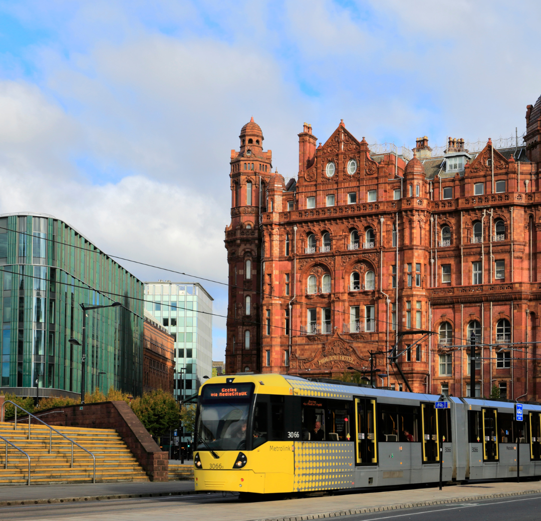 A photo of Manchester city centre, with a tram in the foreground.